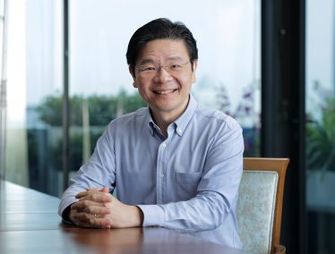 Headshot of Lawrence Wong seated at a table, smiling at the camera.