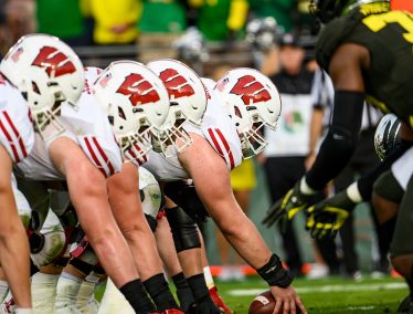 The Badgers' offensive line prepares to snap the ball while playing against the Oregon Ducks.