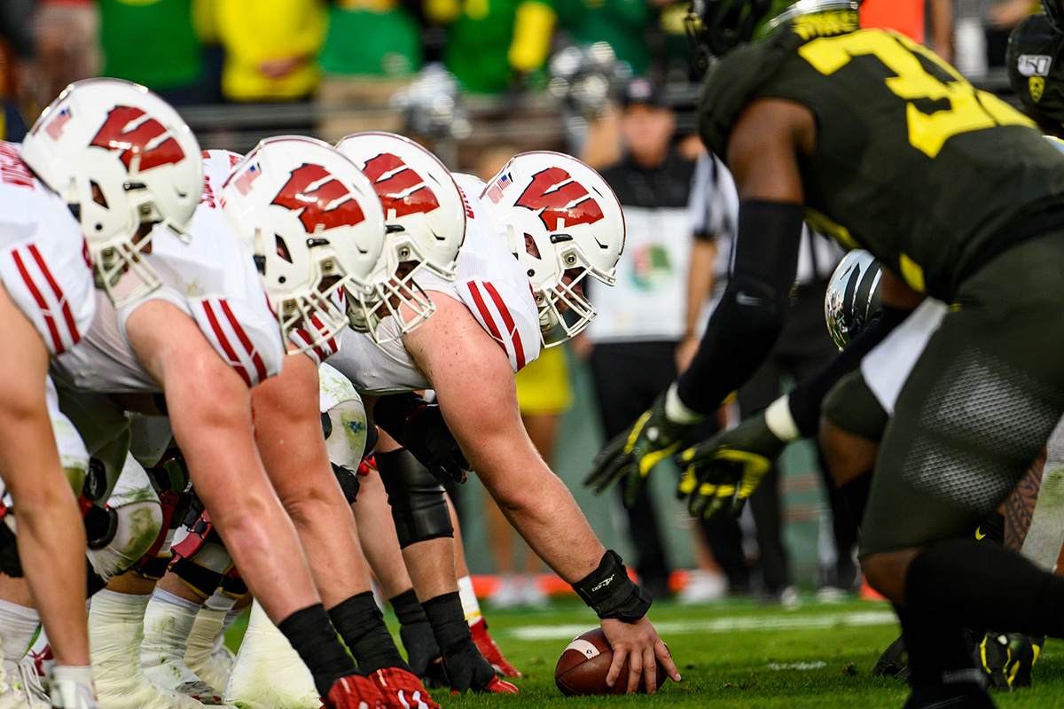 The Badgers' offensive line prepares to snap the ball while playing against the Oregon Ducks.