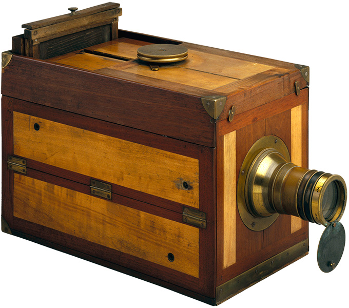 A vintage wooden camera with brass fittings and a lens, showcasing early photographic technology.