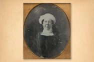 A vintage, framed photograph of Dolley Madison wearing a dark outfit and a white head covering.