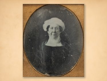 A vintage, framed photograph of Dolley Madison wearing a dark outfit and a white head covering.