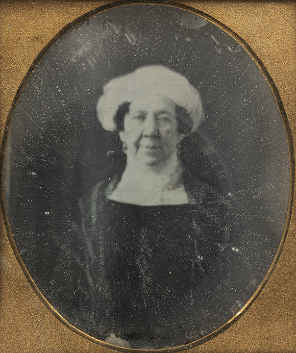 A vintage, framed photograph of Dolley Madison wearing a dark outfit and a white head covering.