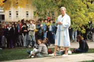 A group of people gathered outdoors on Bascon Hill, with Rodney Dangerfield (as character Thornton Melon) in a bathrobe and slippers among casually dressed students and actors.