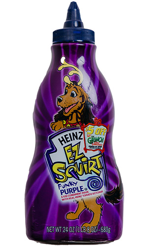 A 24 oz bottle of Heinz EZ Squirt Funky Purple ketchup featuring the cartoon dog from The Grinch on the label.