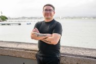 Jorell Meléndez-Badillo standing with arms crossed near a waterfront in Puerto Rico.