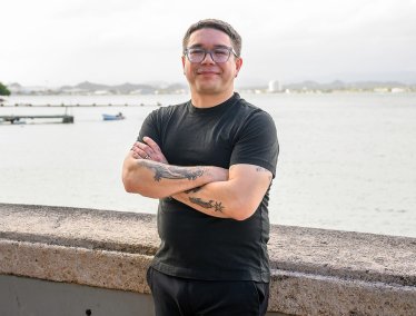 Jorell Meléndez-Badillo standing with arms crossed near a waterfront in Puerto Rico.