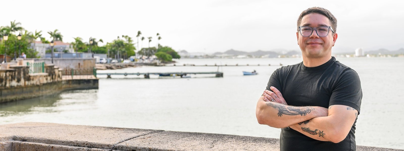 Jorell Meléndez-Badillo standing with arms crossed near a waterfront in Puerto Rico.