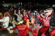 Badger fans decked out in red dance with Bucky Badger mascot