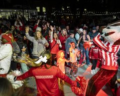 Badger fans decked out in red dance with Bucky Badger mascot