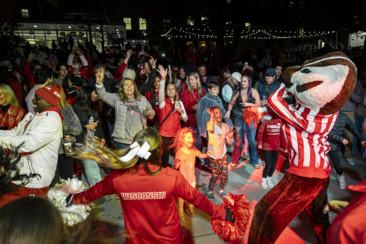 Badger fans decked out in red dance with Bucky Badger mascot
