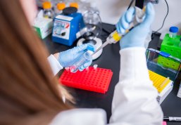 A researcher fills a tube in a lab at Immuto Scientific in Madison