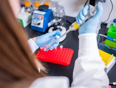 A researcher fills a tube in a lab at Immuto Scientific in Madison