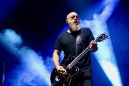 Steve Marker plays guitar against dramatic blue stage lights