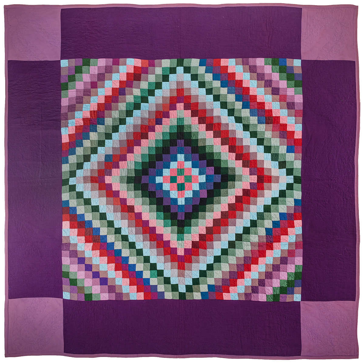 A colorful quilt with a diamond pattern of small squares in various shades, bordered by a wide purple frame.