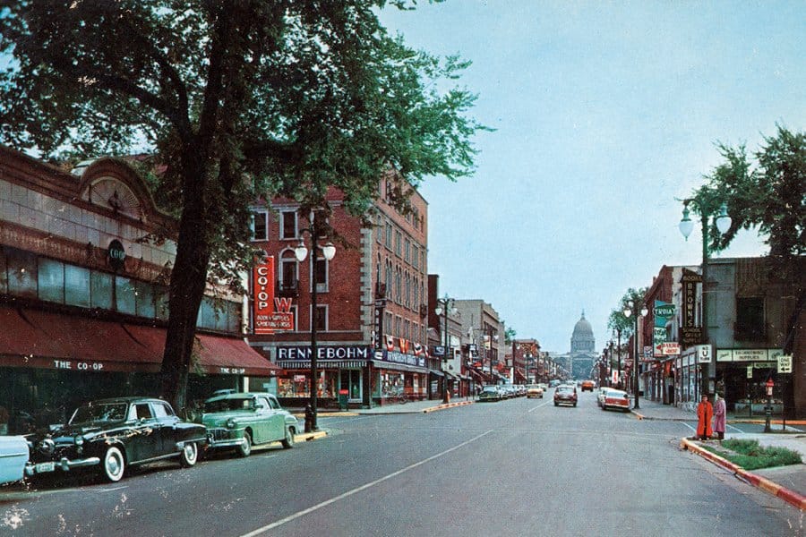 A vintage street scene of State Street with storefronts including 'Rennebohm' and the state capitol building in the background.