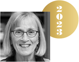 Black and white headshot of Claudia Goldin with an overlapping gold circle representing a Nobel medal, with the year 2023 on it.
