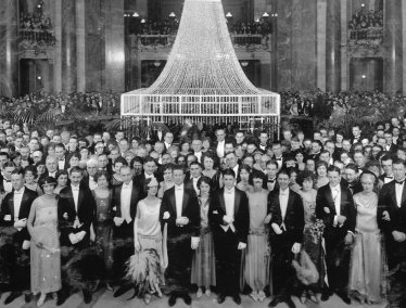 Black and white archival photo of a large crowd of elegantly dressed people poses in the Madison capitol building.