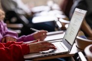 Student takes notes on laptop in lecture hall