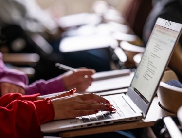 Student takes notes on laptop in lecture hall