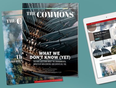 Two print copies of 'The Commons' magazine are layered next to a tablet displaying the publication's digital edition.