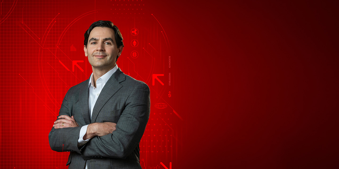 Portrait of Brad Chandler posing with crossed arms against a red graphic background featuring cryptocurrency logos and blockchain graphics.