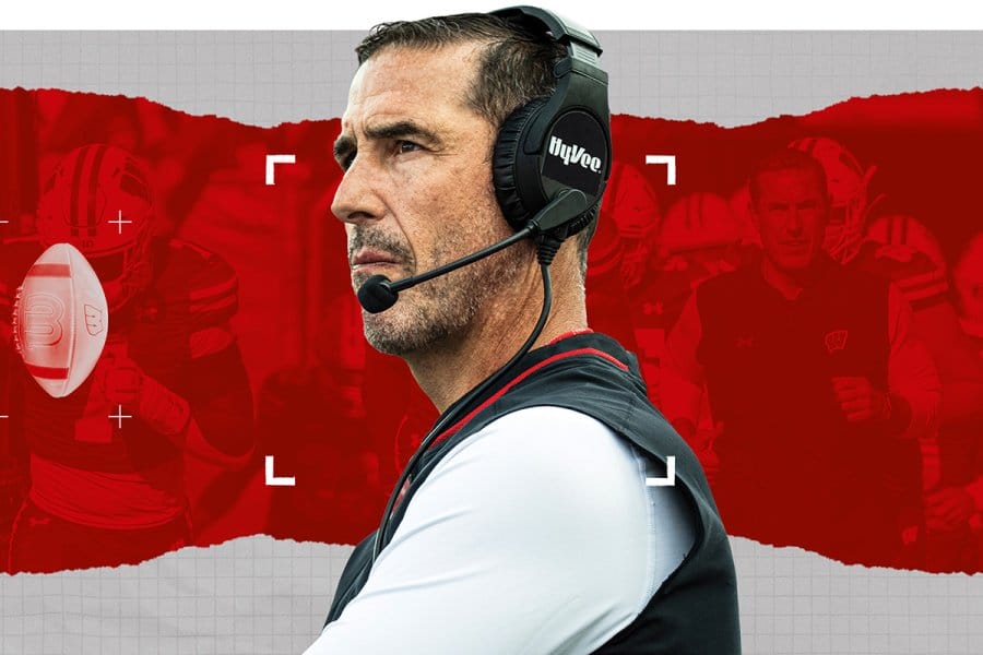 A graphic photo illustration of Wisconsin Badgers head coach Luke Fickell wearing a headset, set against a red torn-paper backdrop featuring football graphics and camera crosshairs.