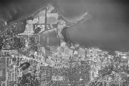 A black-and-white aerial photograph of the UW–Madison campus shoreline along Lake Mendota, showing Picnic Point, University Bay, and surrounding agricultural fields and residential areas.